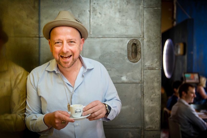 Salvatore Malatesta holds a cup of coffee.