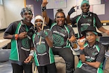 Six Indigenous musicians wearing matching green and black polo shirts and wearing green and black facepaint.