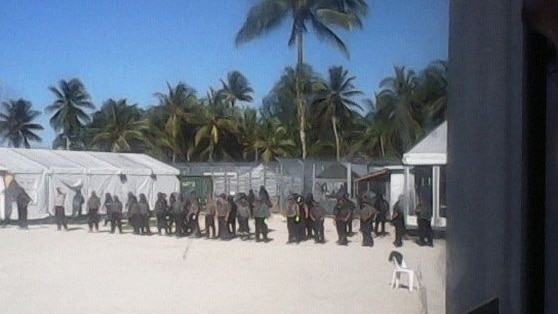 Security contractors stand in a line at Manus Island detention centre