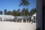 Security contractors stand in a line at Manus Island detention centre