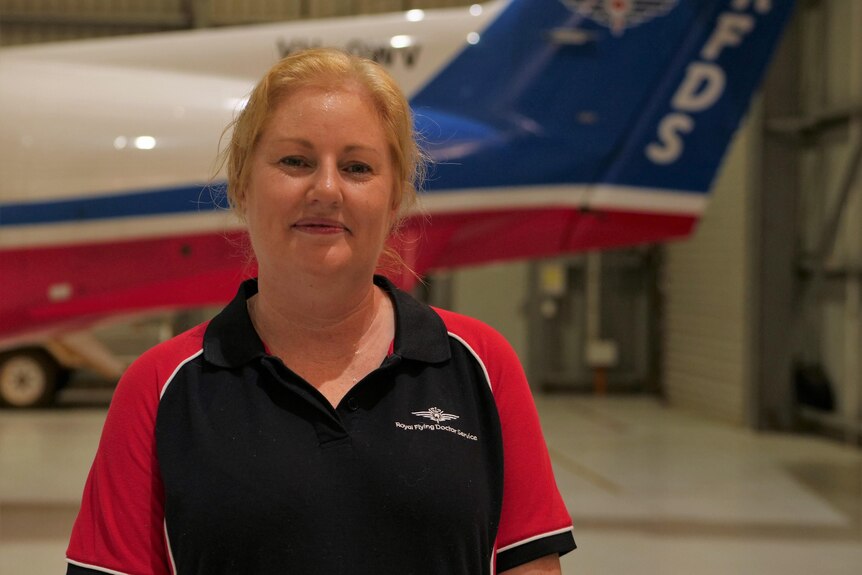 A smiling blonde woman in front of an RFDS jet