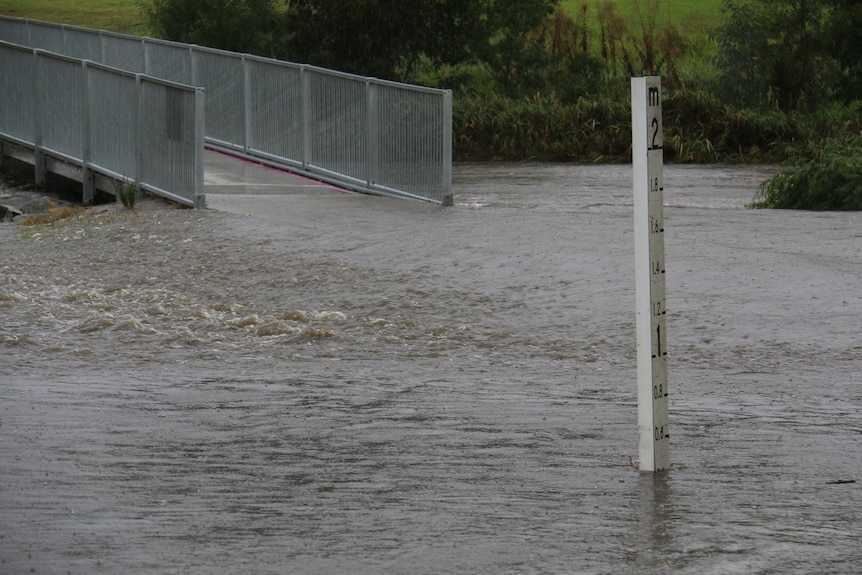 Flood waters push against a bridge