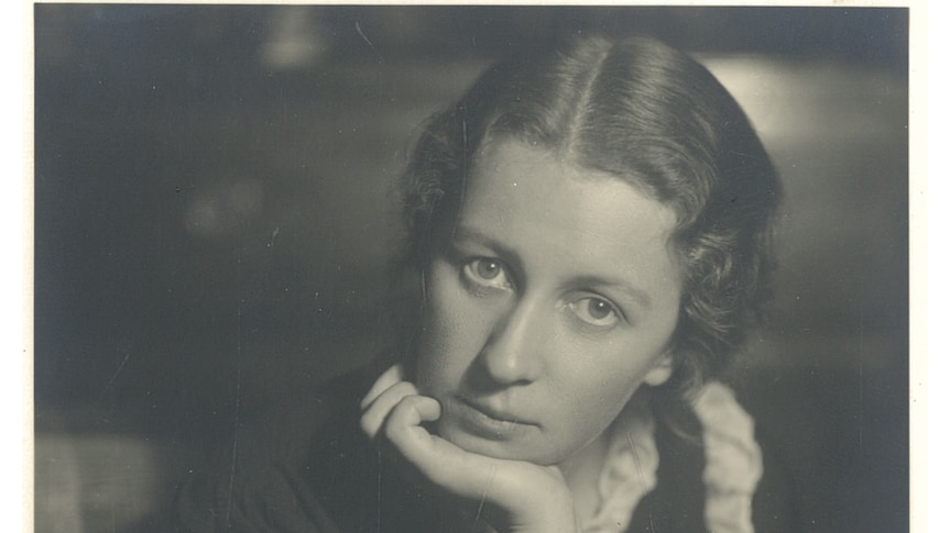 A black and white photo of Edith Emery as a young woman, her chin resting in her hand