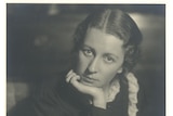 A black and white photo of Edith Emery as a young woman, her chin resting in her hand
