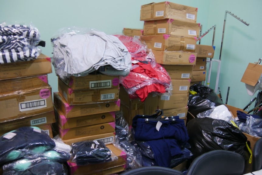 Clothes and boxes in store room.