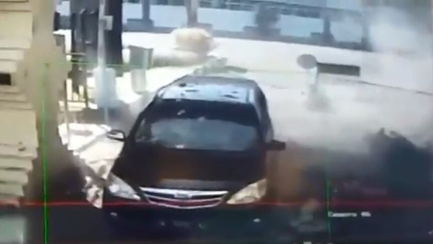 监视摄像头拍摄的画面显示，泗水警署外的一个安全岗哨爆炸。