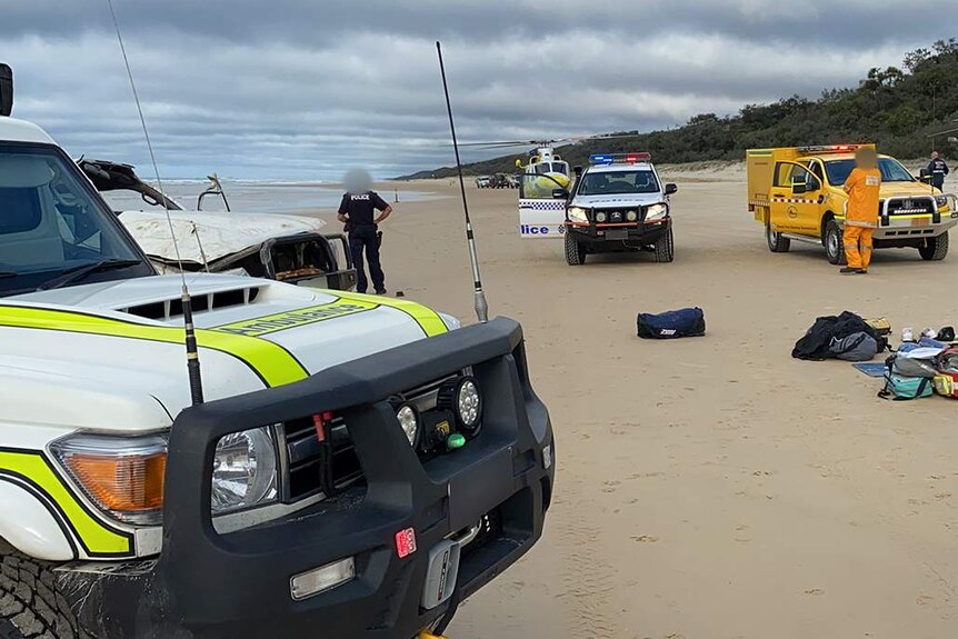 Paramedics and police at the scene of a fatal 4WD rollover on Fraser Island.