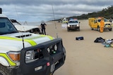 Paramedics and police at the scene of a fatal 4WD rollover on Fraser Island.