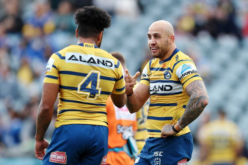 Two Parramatta Eels NRL players celebrate following a try against the Warriors in Gosford.