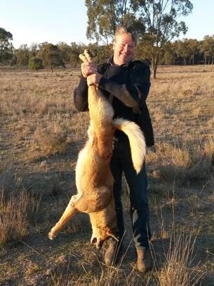 Brendan Slatter holds up a dead wild dog