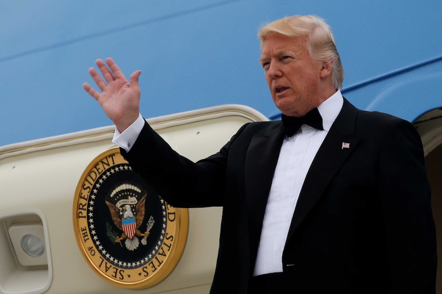 Donald Trump in black tie emerging from Air Force One