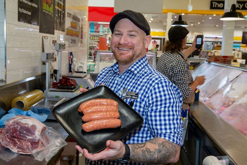 Butcher Reggie Brook holds a tray of sausages at Parkhurst Quality Meats in Rockhampton