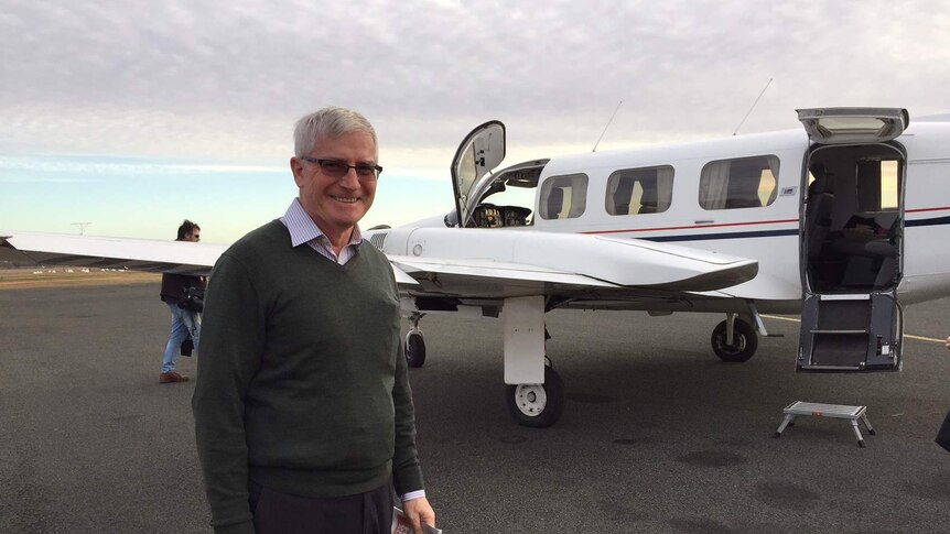Peter Macdonald stands next to a plane at the Condobolin airport