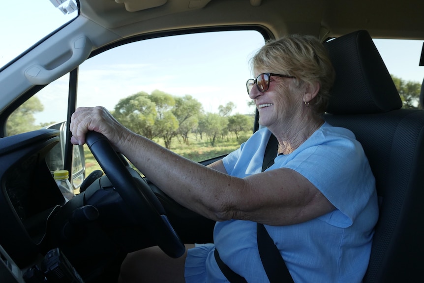 An older woman driving a bus