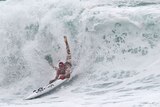 A competitor negotiates a huge wave during the board leg of the Open Ironman heats at the Australian