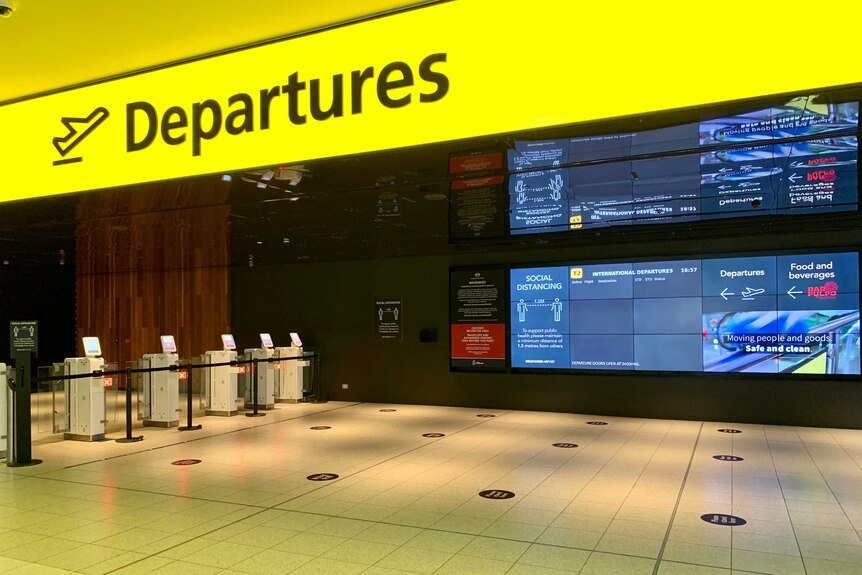 An empty departure board with a yellow sign which says 'departures'.