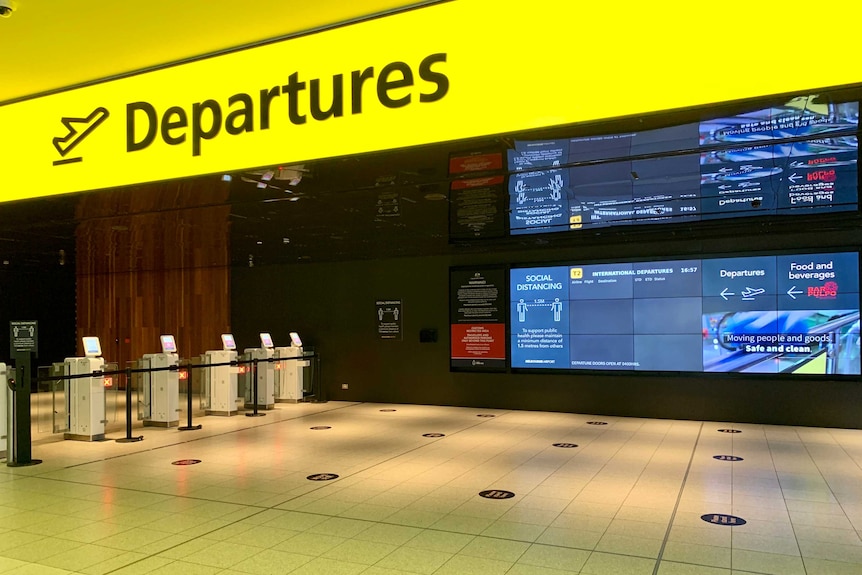 An empty departure board with a yellow sign which says 'departures'.