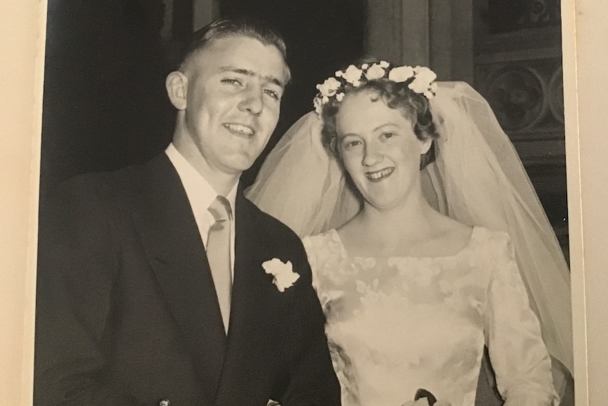 A black and white photo from 1957 of a young couple of their wedding day.