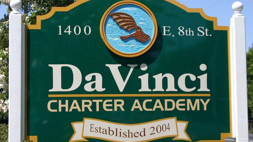A green sign with a stylised image of a bird reads "Da Vinci Charter Academy Established 2004"