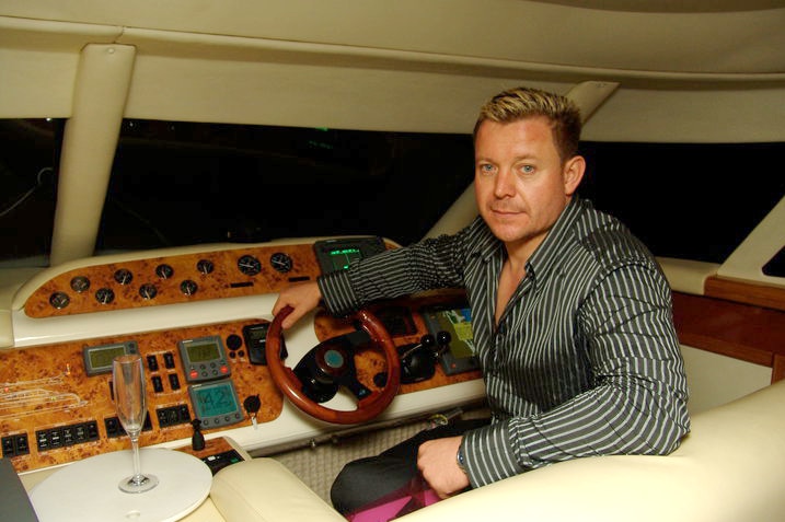 Gold Coast businessman Vitali Roesch sits in a boat.