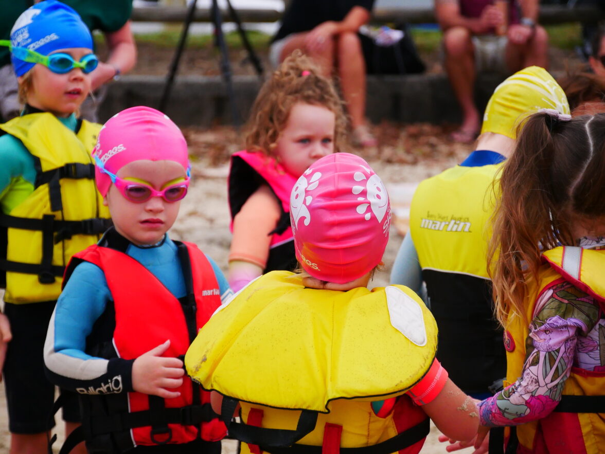 Children in lifejackets and swimming costumes