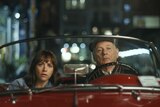 Rashida Jones and Bill Murray sit in an old red convertible in the film On the Rocks