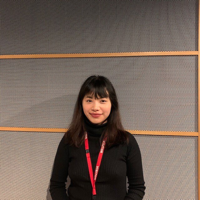 picture of Jillian Nguyen wearing a black jumper standing in front of a grey backdrop