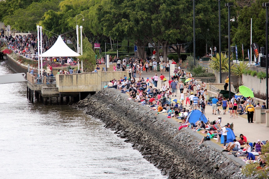 People begin to gather along the edge of the Brisbane River in readiness for Riverfire.