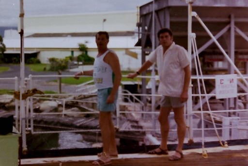 Two men stand on a docked ship in Cairns