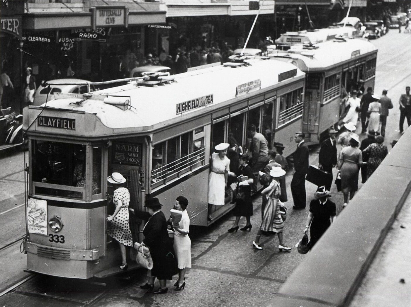 A black and white photo of people boarding a tram in Brisbane