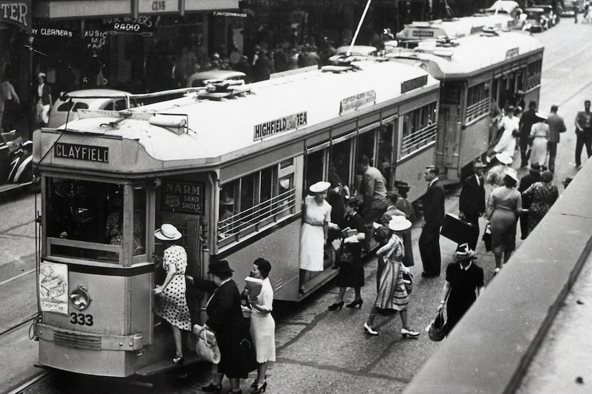 A black and white photo of people boarding a tram in Brisbane