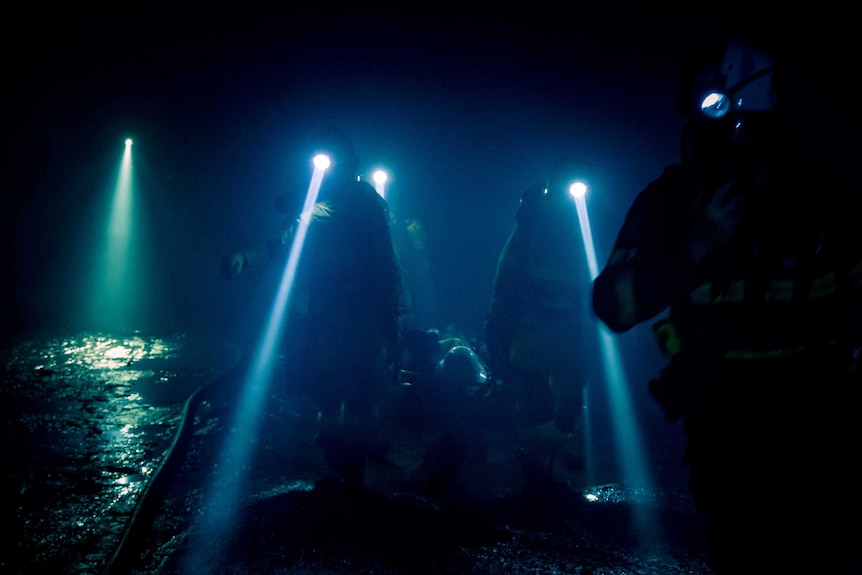 Mine workers in an underground mine during a firefighting exercise.