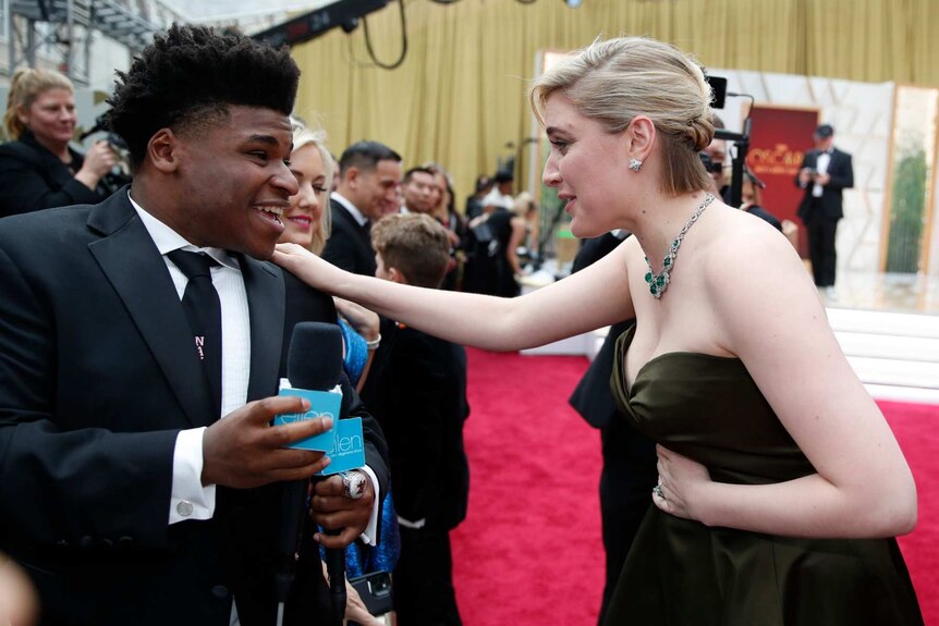 Greta Gerwig, right, talks to Jerry Harris on the red carpet at the Oscars at the Dolby Theatre in Los Angeles