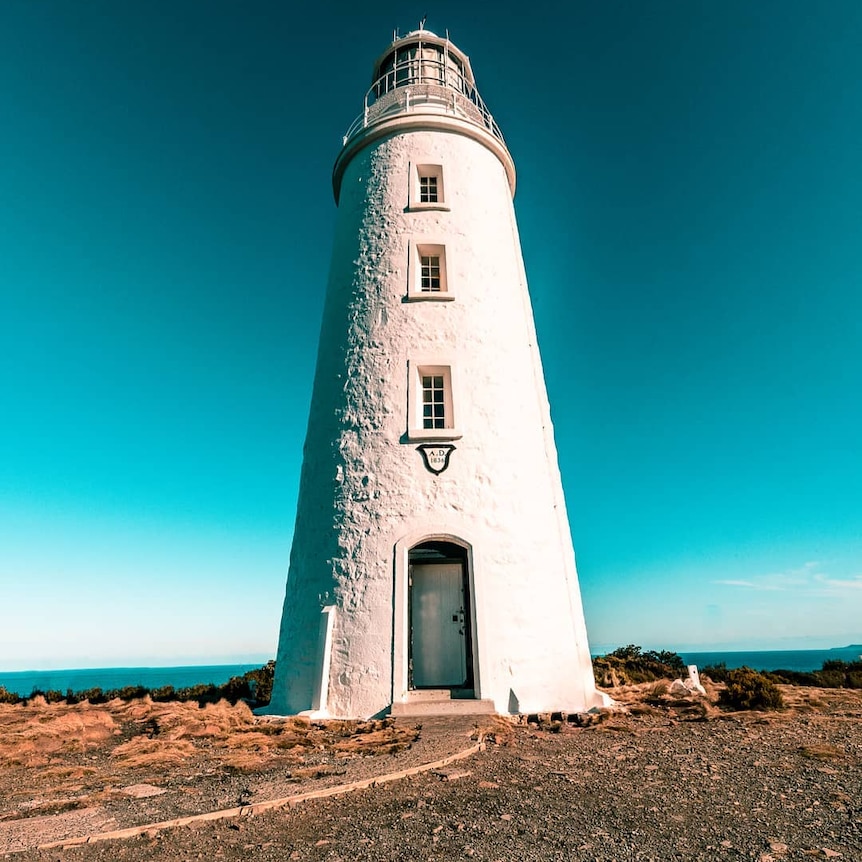 A lighthouse against bright blue skies.
