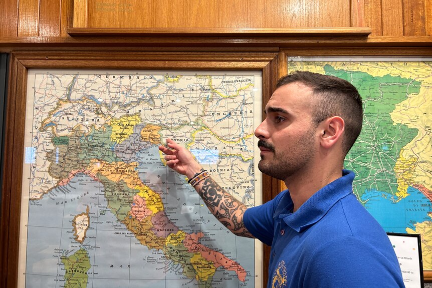 A man points to a map of Italy showing the Friuli Venezia Giulia region.