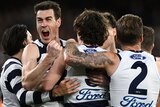 Jeremy Cameron screams in delight while in a group of Cats teammates