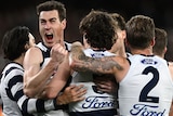 Jeremy Cameron screams in delight while in a group of Cats teammates