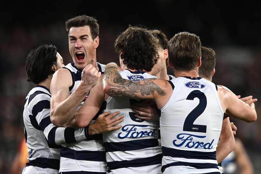 Jeremy Cameron screams in delight while in a group of Cats teammates