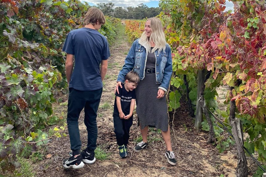 Two young adults and a young boy standing in a vinyard