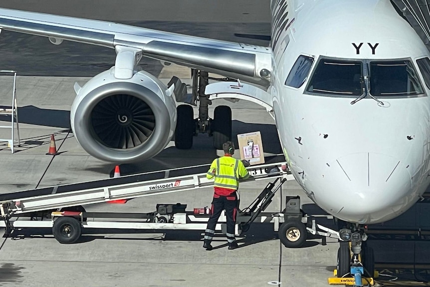 A ramp loading a box into an airplane