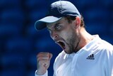 Aslan Karatsev pumps his fist and shouts at the Australian Open.