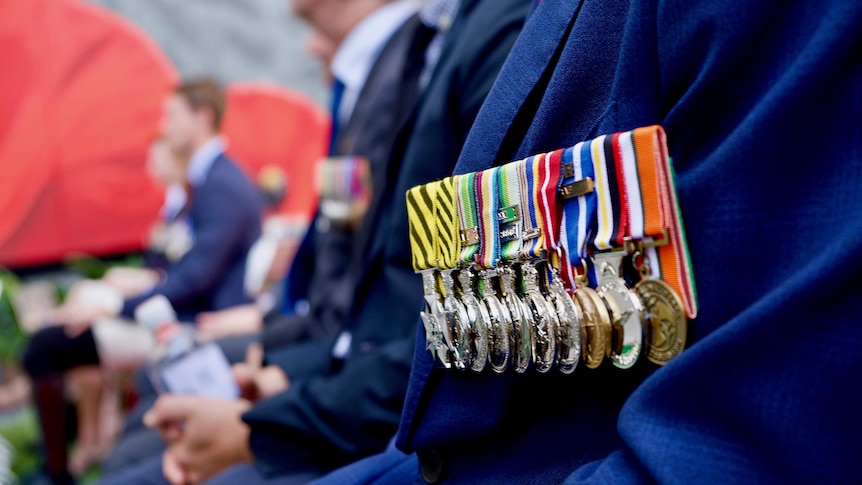 Close-up photo of a veteran's medals pinned to his chest.
