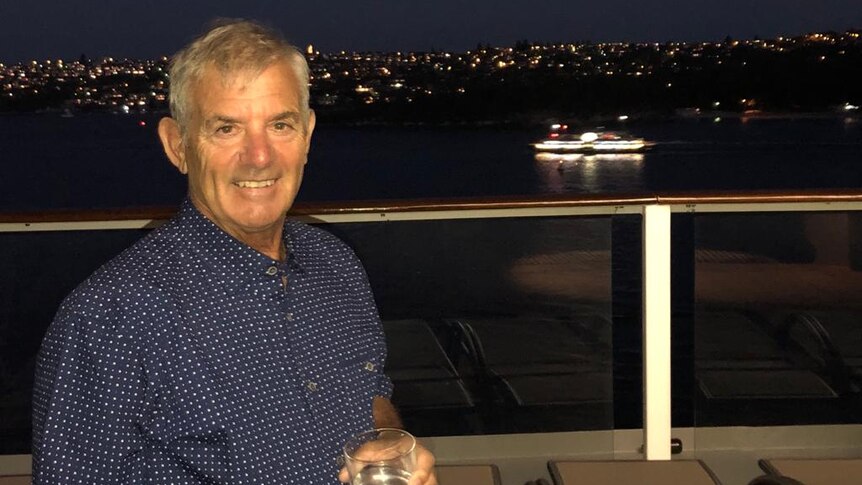 A smiling Ray Daniels drinking water on a boat.