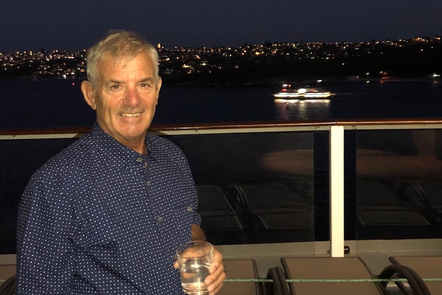 A smiling Ray Daniels drinking water on a boat.