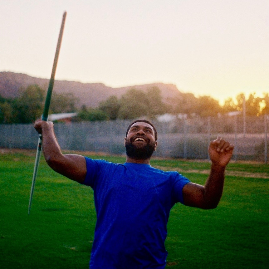 Inosi Bulimairewa is holding a javelin and has his hands up in celebration.