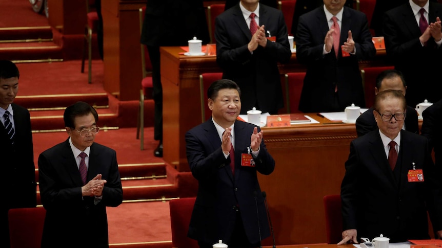 Chinese President Xi Jinping is standing up and clapping at the national congress.