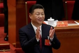 Chinese President Xi Jinping is standing up and clapping at the national congress.