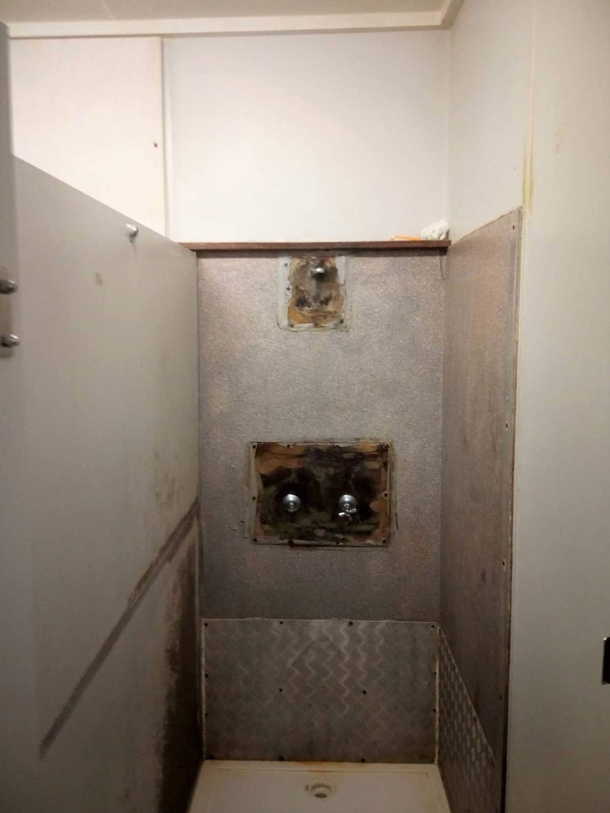 A dirty shower with mould and damage