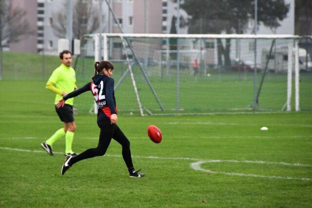 A woman in mid kicking action on an oval.