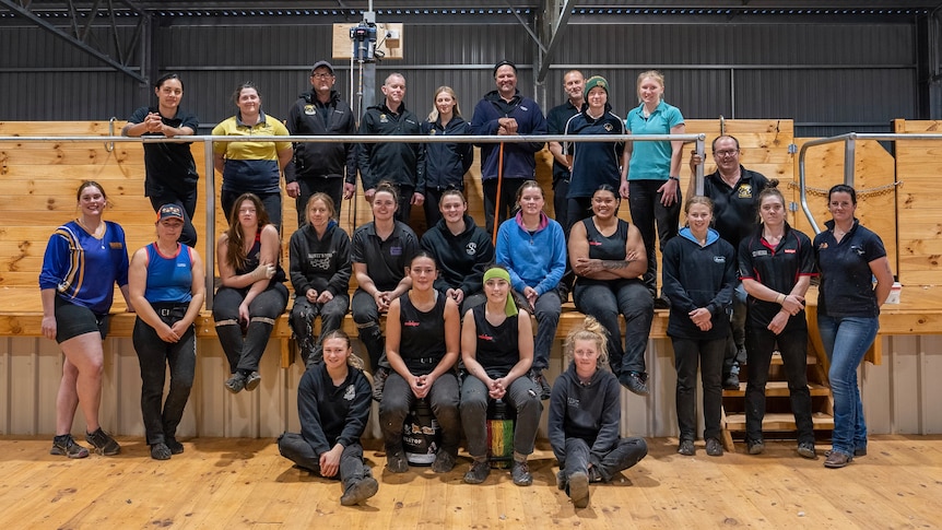 Women standing in a shearing shed.